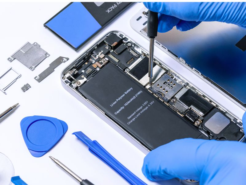 Technicien installant une nouvelle batterie dans un smartphone.